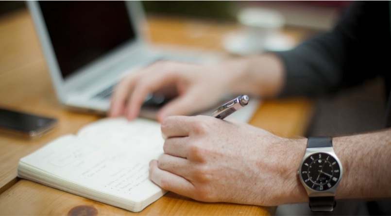 Person writing in notebook.